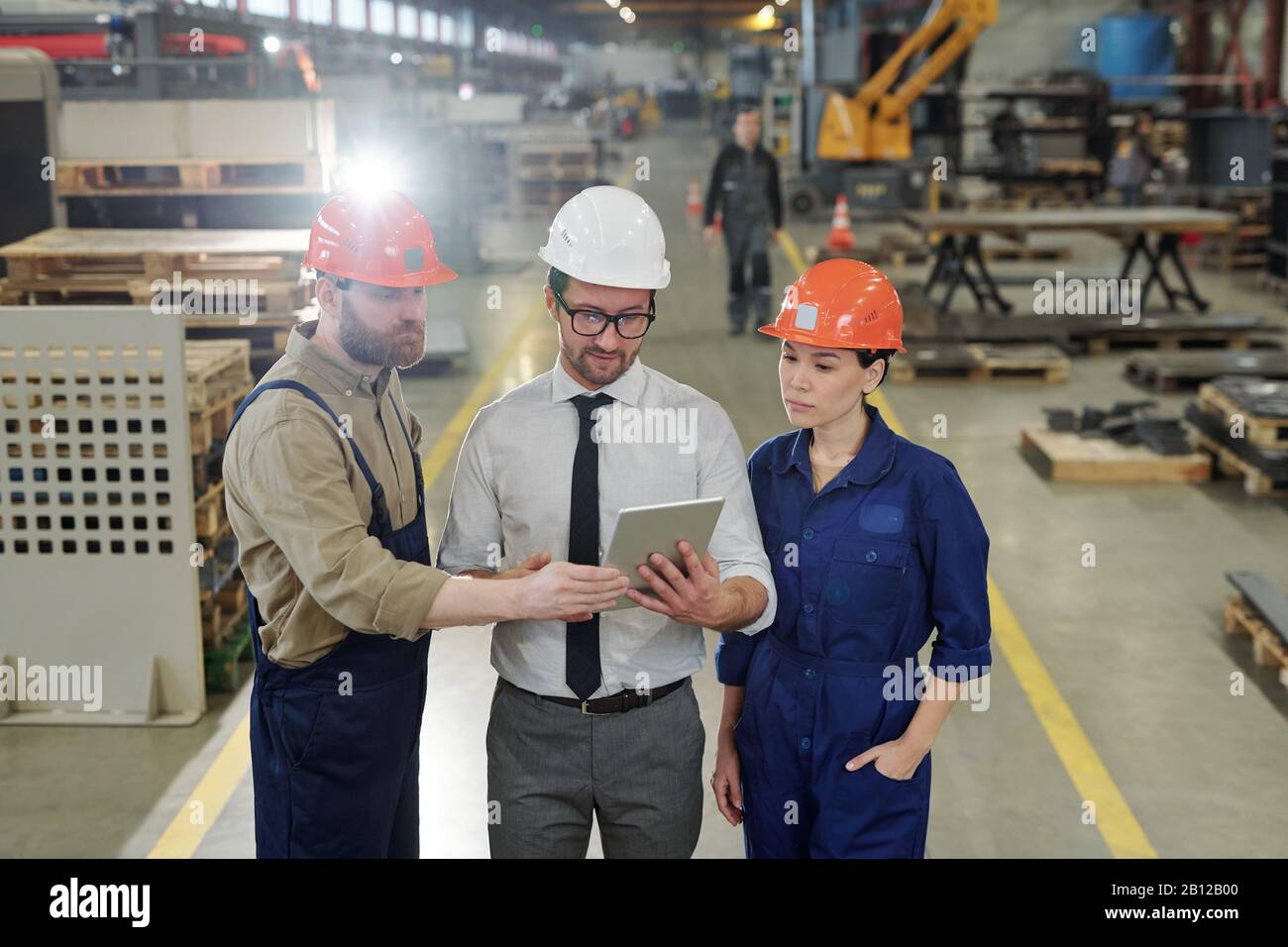 Group of young engineers looking at technical data on tablet display Stock Photo