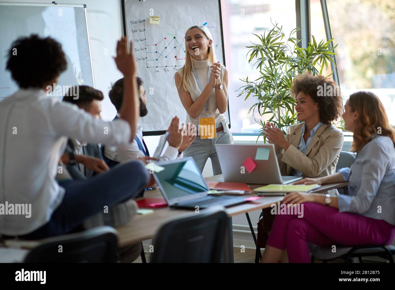 woman clapping hands with her associates on a business meeting. business, meeting, casual briefing concept Stock Photo