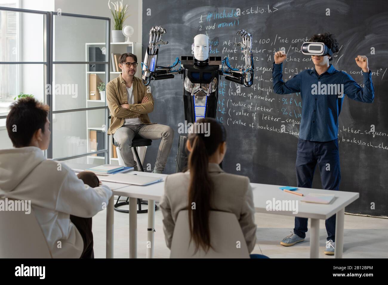 Contemporary student with vr headset demonstrating abilities of automation robot Stock Photo