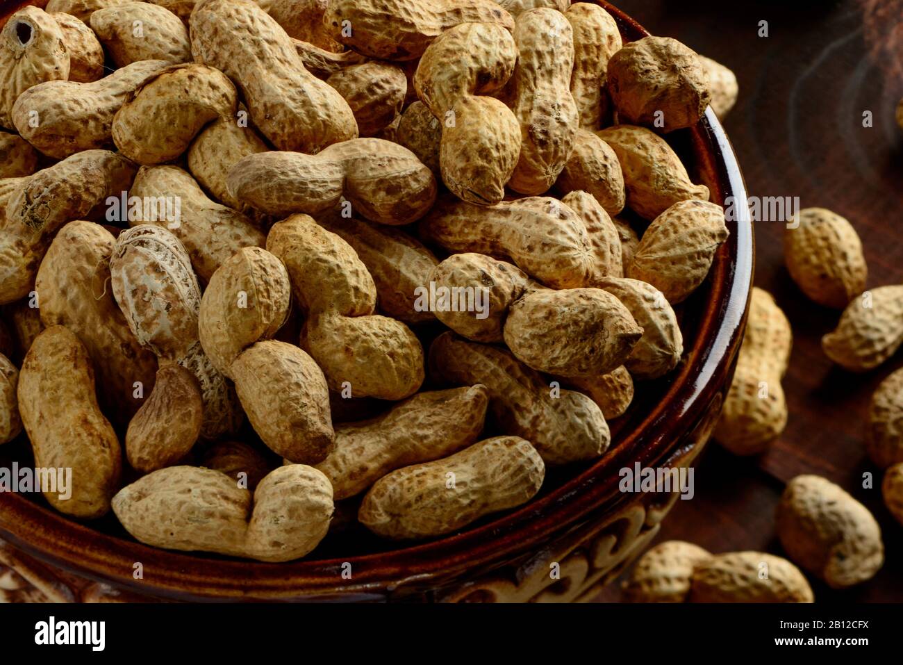 Peanuts in a bowl on a dark background. Peanuts in a shell. Healthy