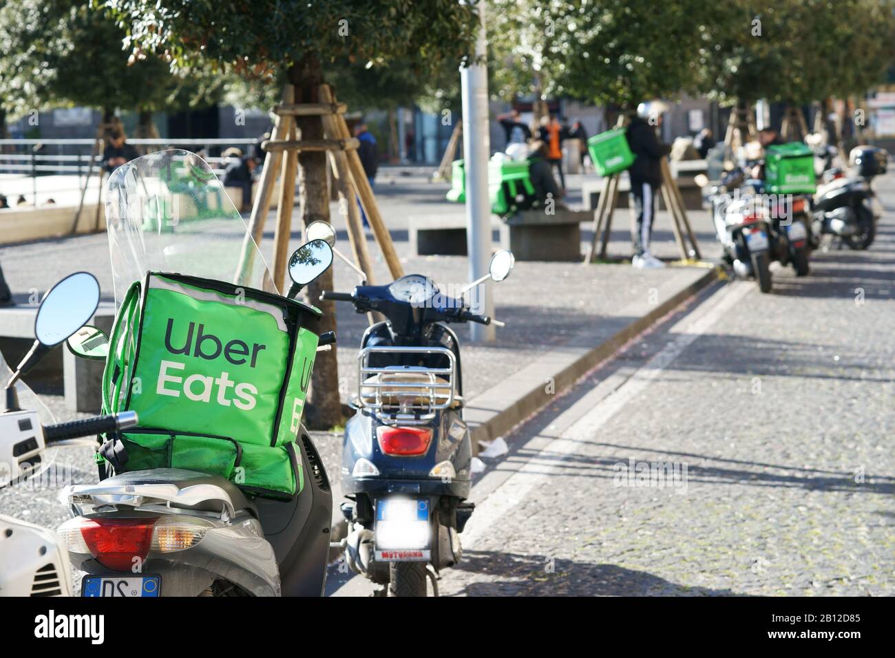 Uber Eats, motor scooters with the typical green backpack to delivers