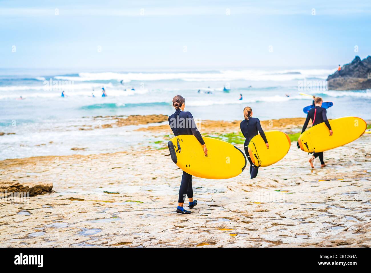View on group of surfer at the beach of Ribeira d'Ilhas next to Ericeira, Portugal Stock Photo