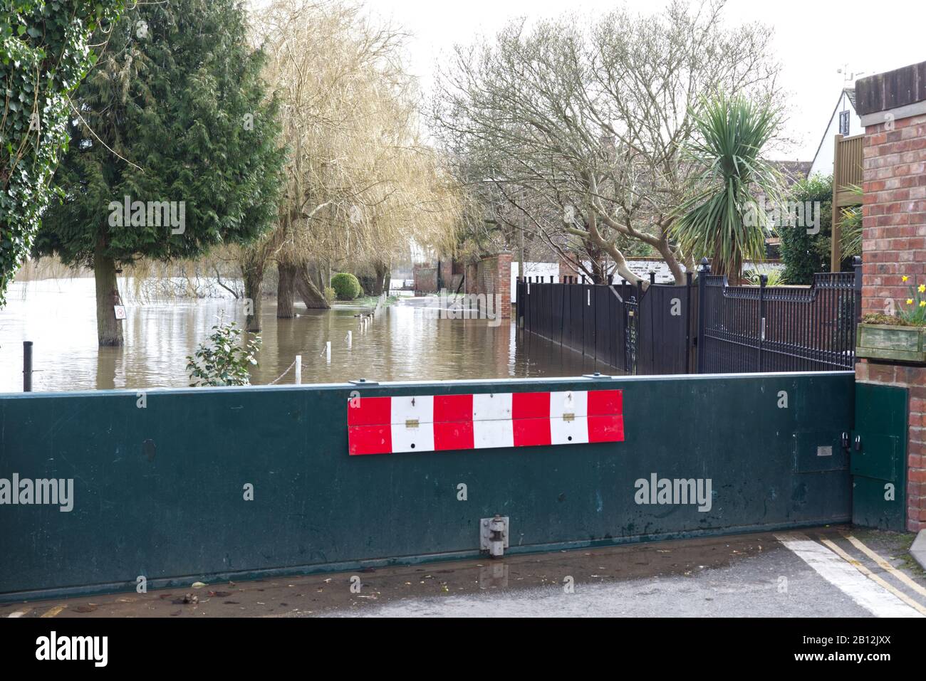 murky flood waters cutting off road and housing in the town of Upton