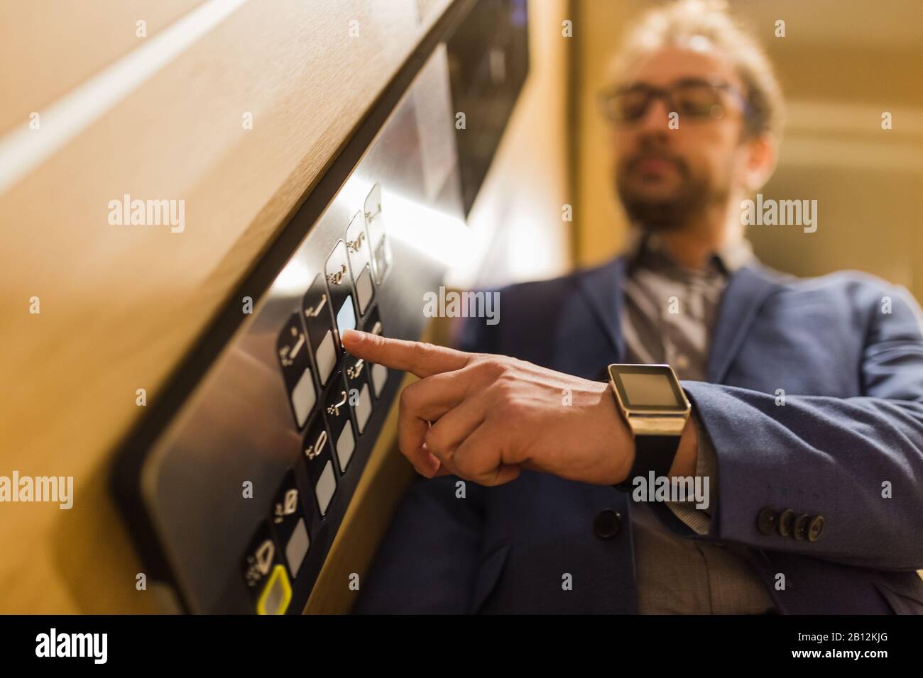 Man pressing modern elevator button with his forefinger. Stock Photo