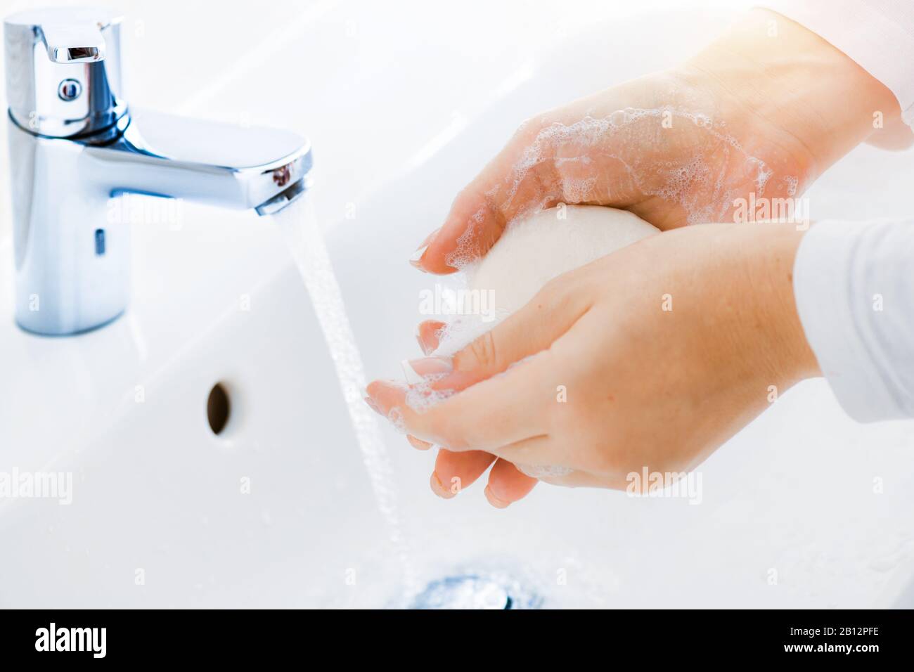 Woman use soap and washing hands under the water tap. Hygiene concept ...