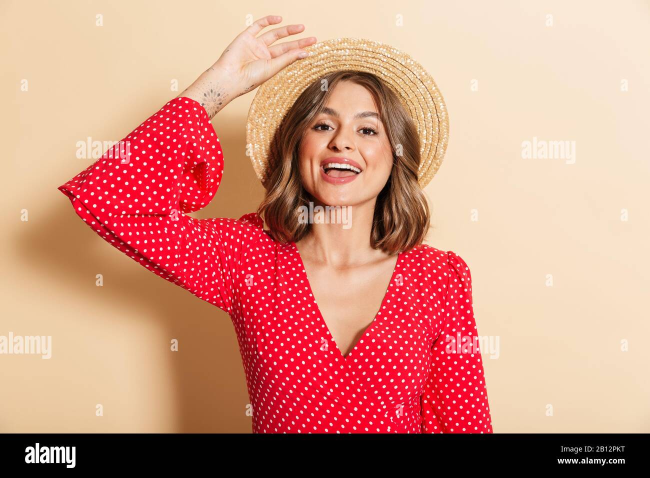 Photo of pretty woman in red dress and straw hat smiling at camera ...