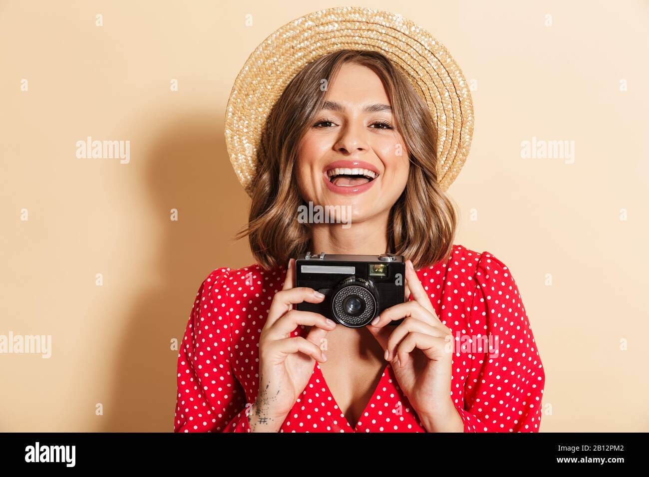 Photo of beautiful woman in red dress and straw hat smiling while ...