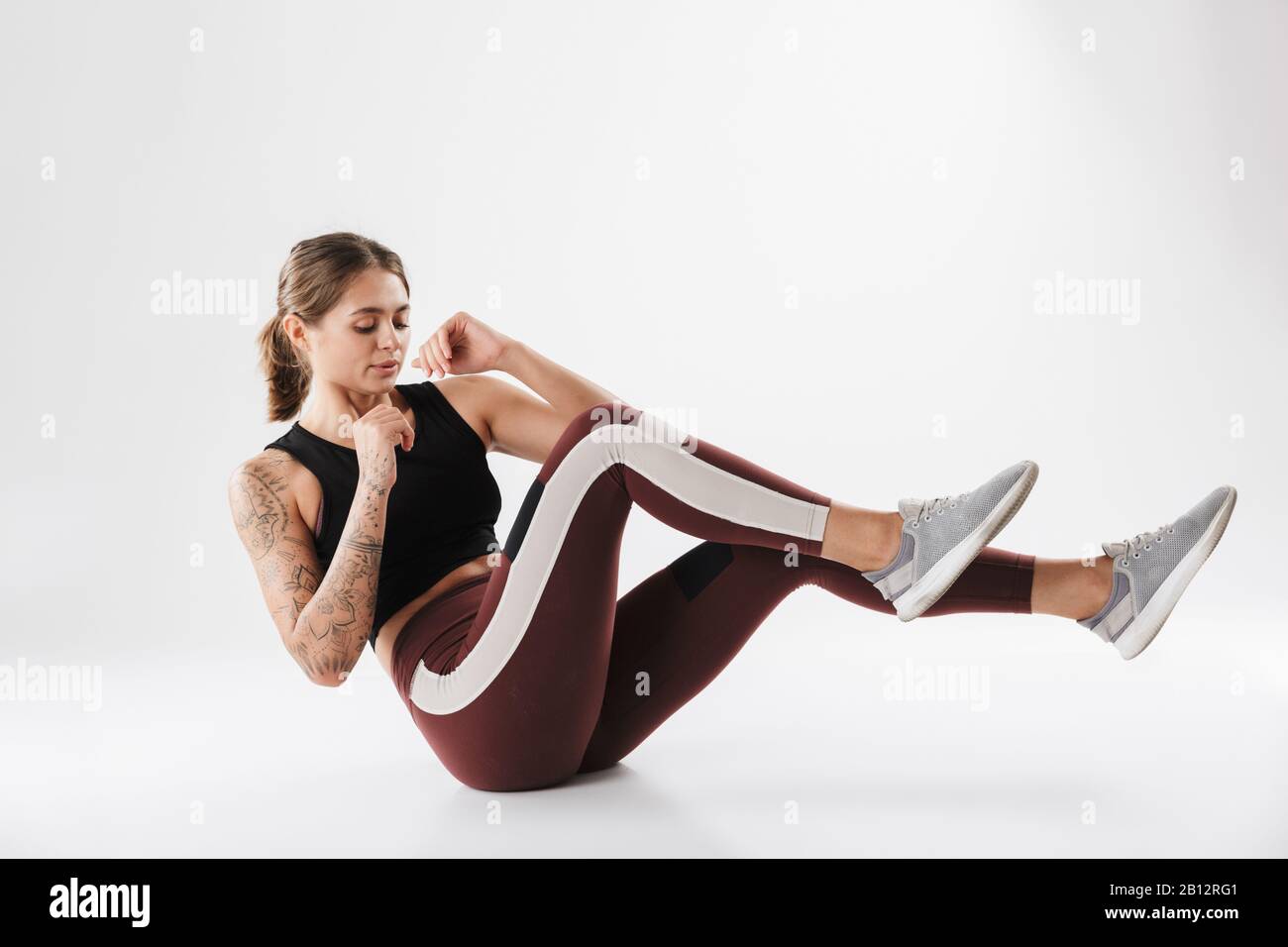 Image of attractive woman in sportswear training and doing criss cross  crunches isolated over white background Stock Photo - Alamy