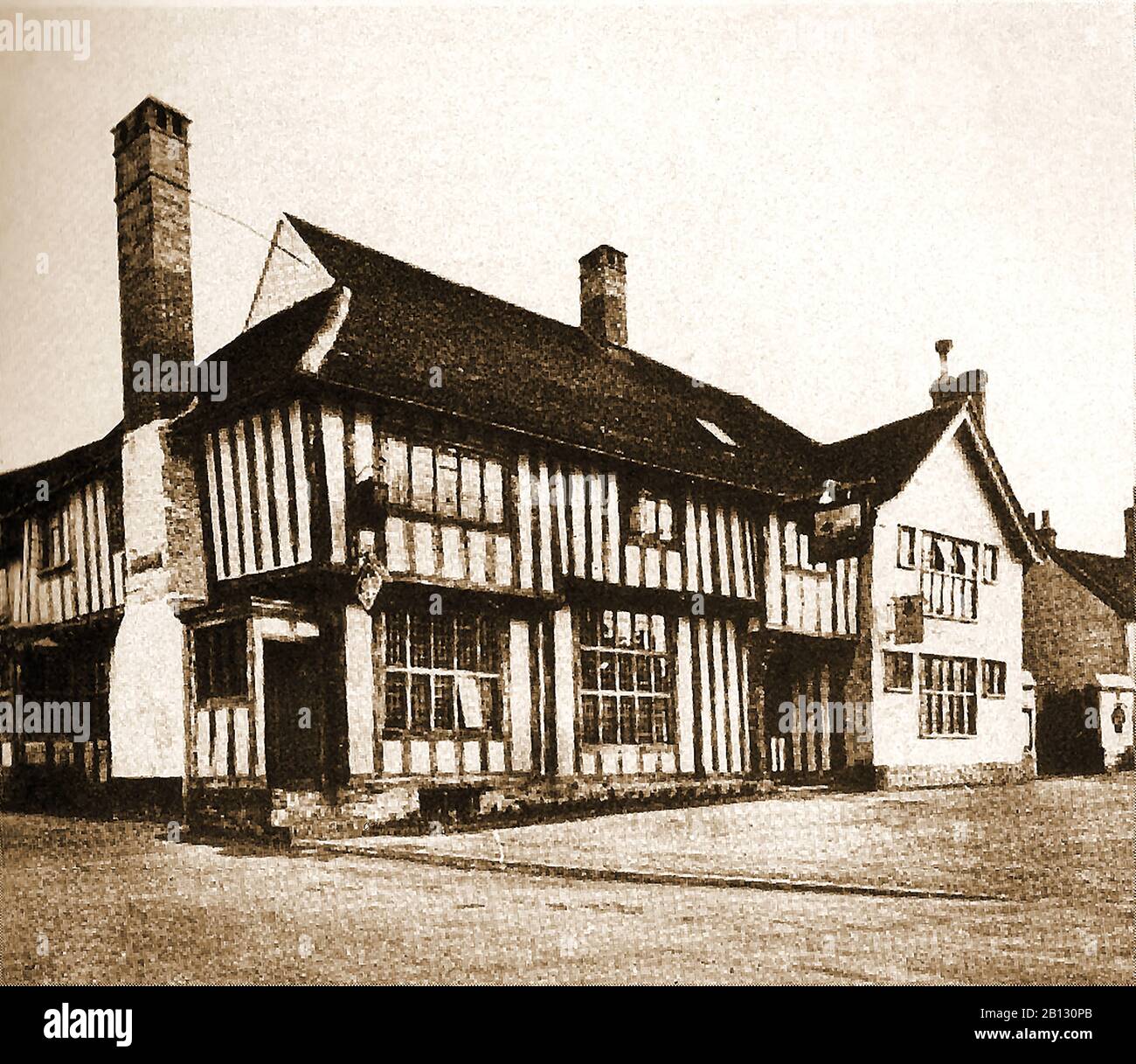 c 1940's -  An old photograph of the historic timbered Bull Inn at Long Melford , a Suffolk village in England(Originally a Merchant's House built in 1450 and later a coaching inn) . The ghost of Richard Evered who was stabbed to death in the hotel  in 1648 is said to still haunt the hotels halls, rooms (particularly room 4)  and corridors. A beam in the lounge is carved with the image of a ‘Wildman’ or ‘Woodwose, a similar  mythical being like the green man, but with a full body. Stock Photo