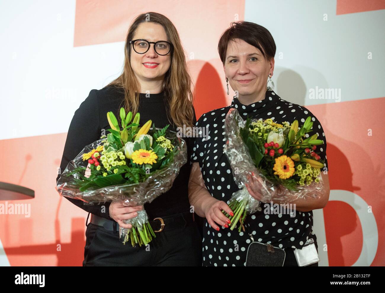 Templin, Germany. 22nd Feb, 2020. Anja Mayer (l), and Katharina Slanina, newly elected state chairwoman of the party Die Linke in Brandenburg, stand after the election with flowers at the state party conference of Die Linke in Brandenburg. Credit: Christophe Gateau/dpa/Alamy Live News Stock Photo