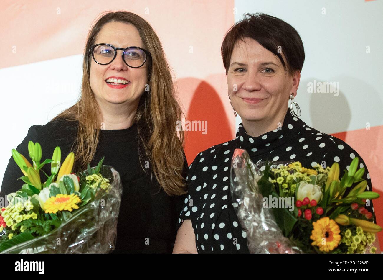 Templin, Germany. 22nd Feb, 2020. Anja Mayer (l), and Katharina Slanina, newly elected state chairwoman of the party Die Linke in Brandenburg, stand after the election with flowers at the state party conference of Die Linke in Brandenburg. Credit: Christophe Gateau/dpa/Alamy Live News Stock Photo