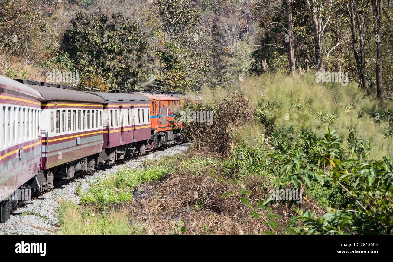 Express train is going to the high mountain with the diesel electric locomotive through the national park,northern of Thailand. Stock Photo