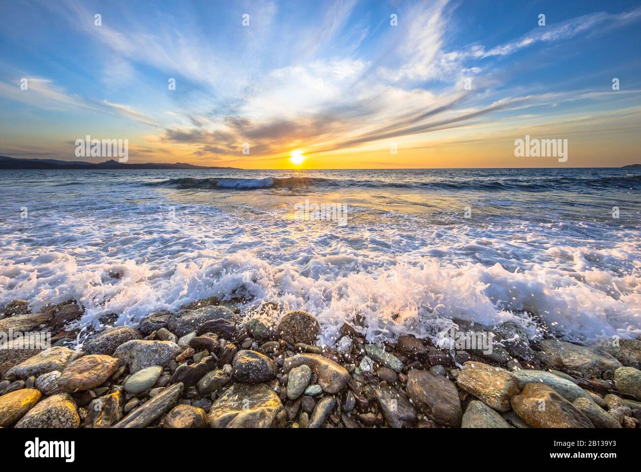 Waves of the Mediterranean sea breaking on pebble beach near Farinole Cap Corse, Corsica, France Stock Photo
