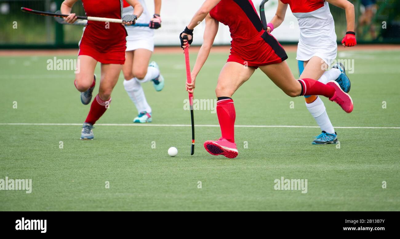 Field hockey players challenge eachother for possession of the ball on the midfield battle of a hockey mach Stock Photo