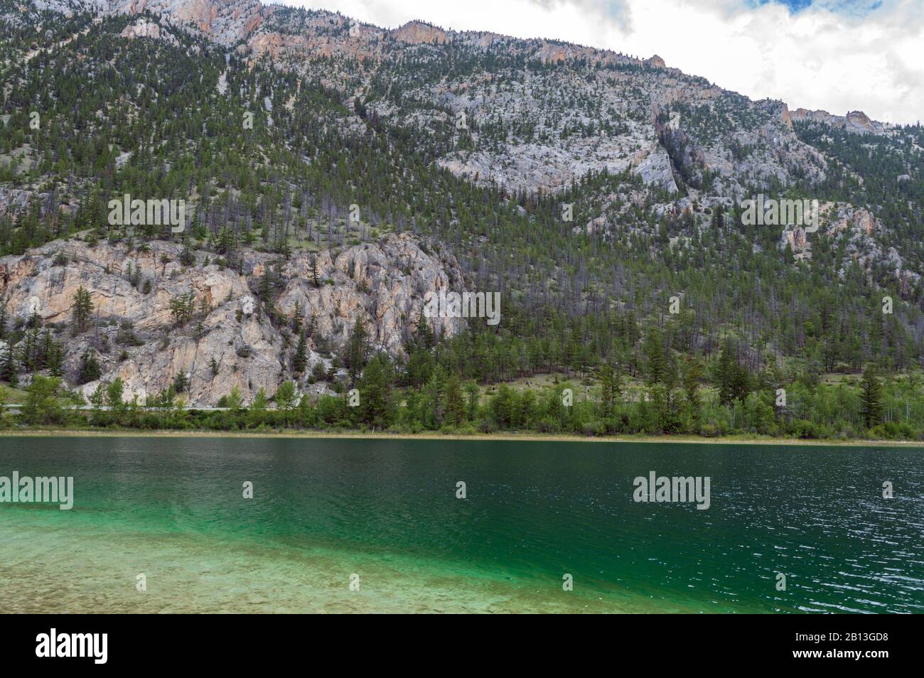 Mountains rise above the shore of Crown Lake in Marble Canyon Provincial Park, British Columbia, Canada Stock Photo