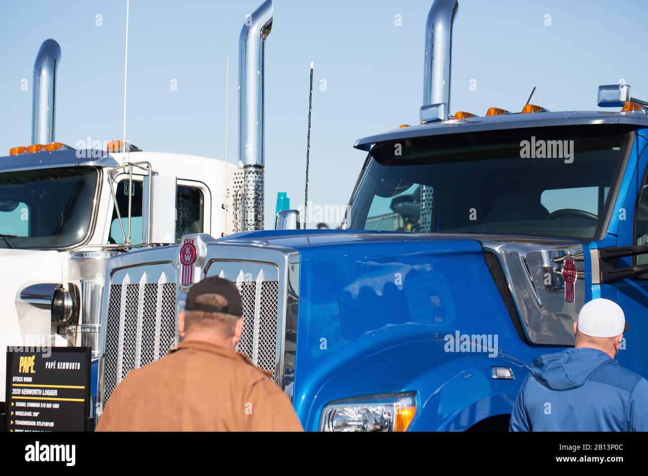 Two men looking at new Kenworth semi trucks at the Oregon Logging
