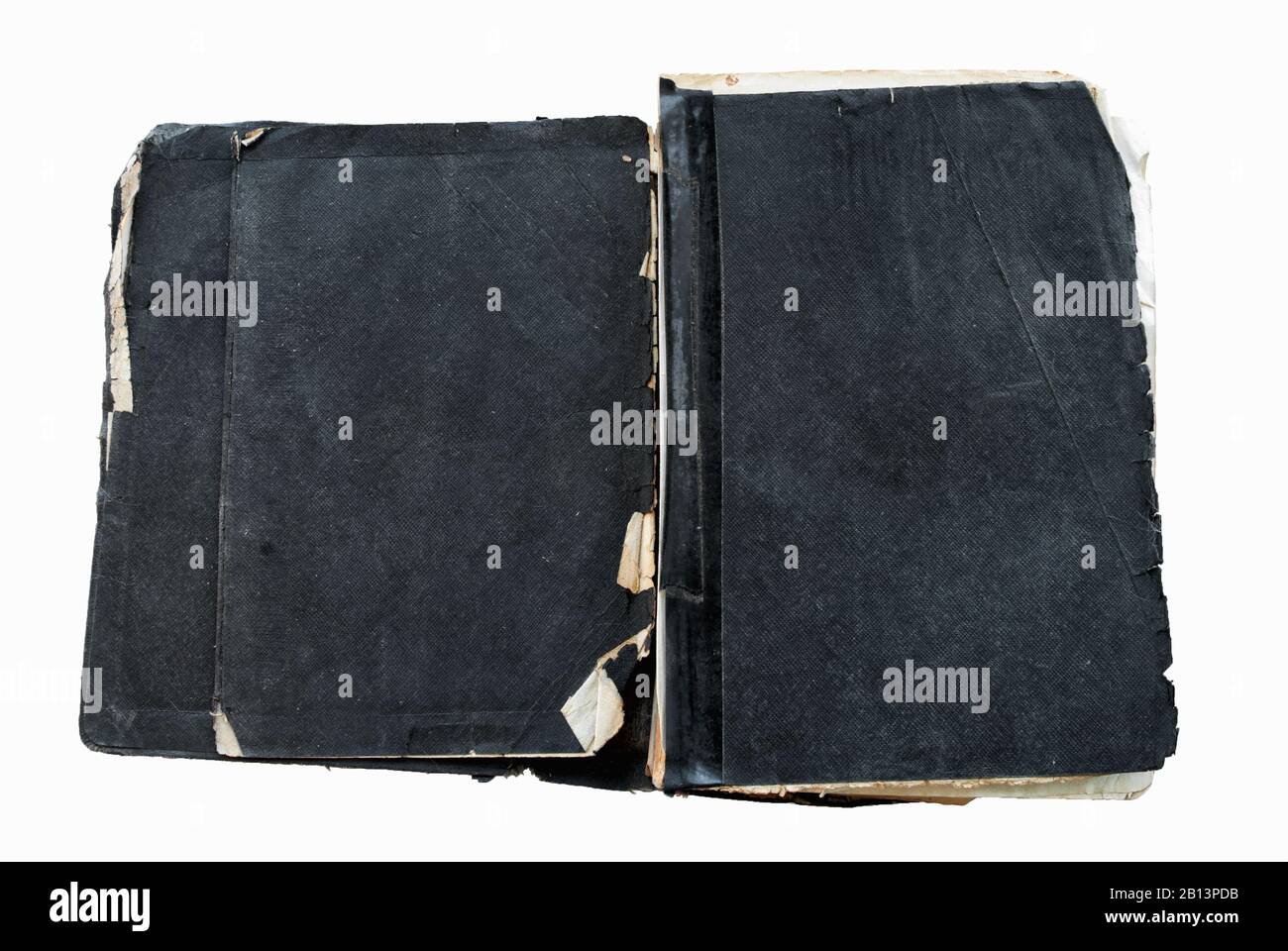 Old black grungy leather bound Bible that is opened. It is torn, ripped, stained, weathered, frayed and very old. Stock Photo