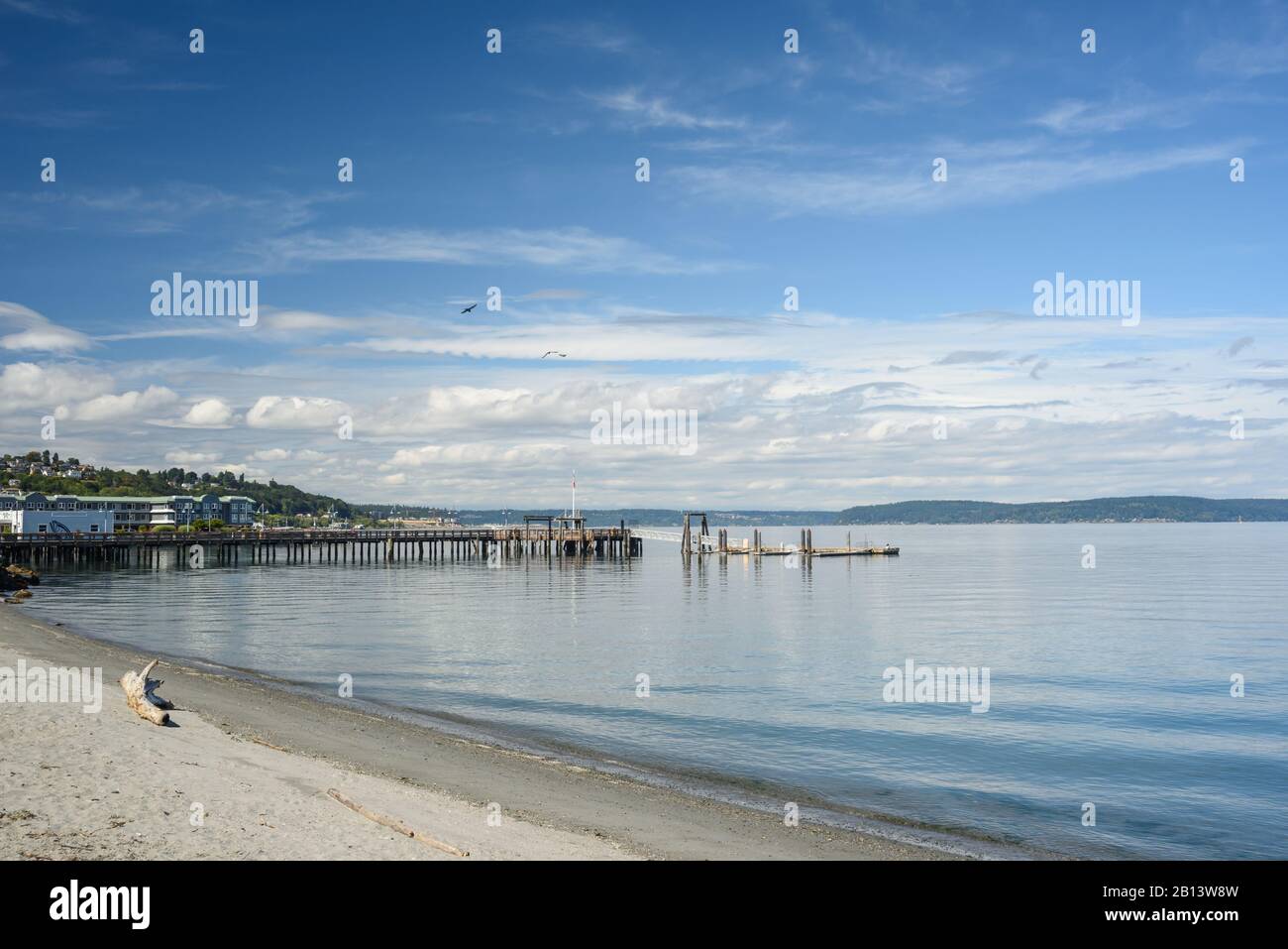 Small quiet beach tucked along Ruston Way in Tacoma on a calm summer afternoon. Stock Photo