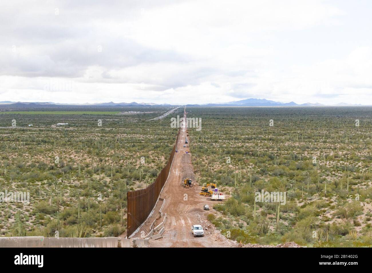 Looking west, midway atop Monument Mountain. Barrier recedes into the horizon. The Tucson 2 project spans five miles, near Douglas AZ, February 11, 2020. The U.S. Army Corps of Engineers, South Pacific Border District is providing contracting services, including design and construction oversight, of Department of Defense-funded Southwest border barrier projects in California, Arizona, New Mexico and Texas at the direction of the Administration and at the request of Department of Homeland Security, Customs and Border Protection. (no one in this image crossed the international border) Stock Photo