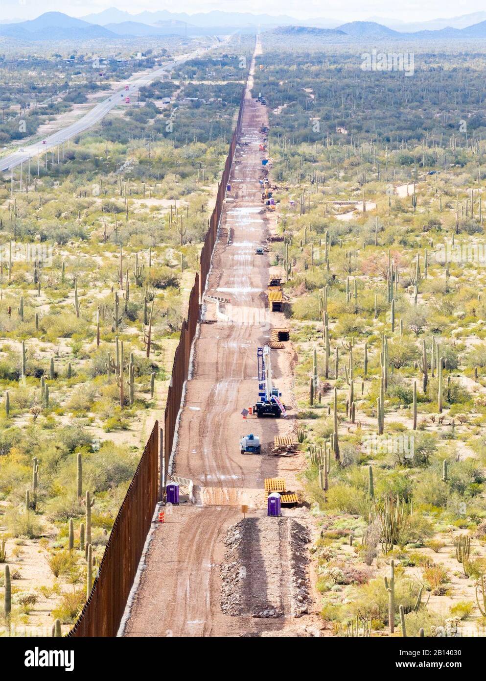 Detailed shot of barrier and adjacent utility road. Looking west, midway atop Monument Mountain. Barrier recedes into the horizon. The Tucson 2 project spans five miles, near Douglas AZ, February 11, 2020. The U.S. Army Corps of Engineers, South Pacific Border District is providing contracting services, including design and construction oversight, of Department of Defense-funded Southwest border barrier projects in California, Arizona, New Mexico and Texas at the direction of the Administration and at the request of Department of Homeland Security, Customs and Border Protection. (no one in thi Stock Photo