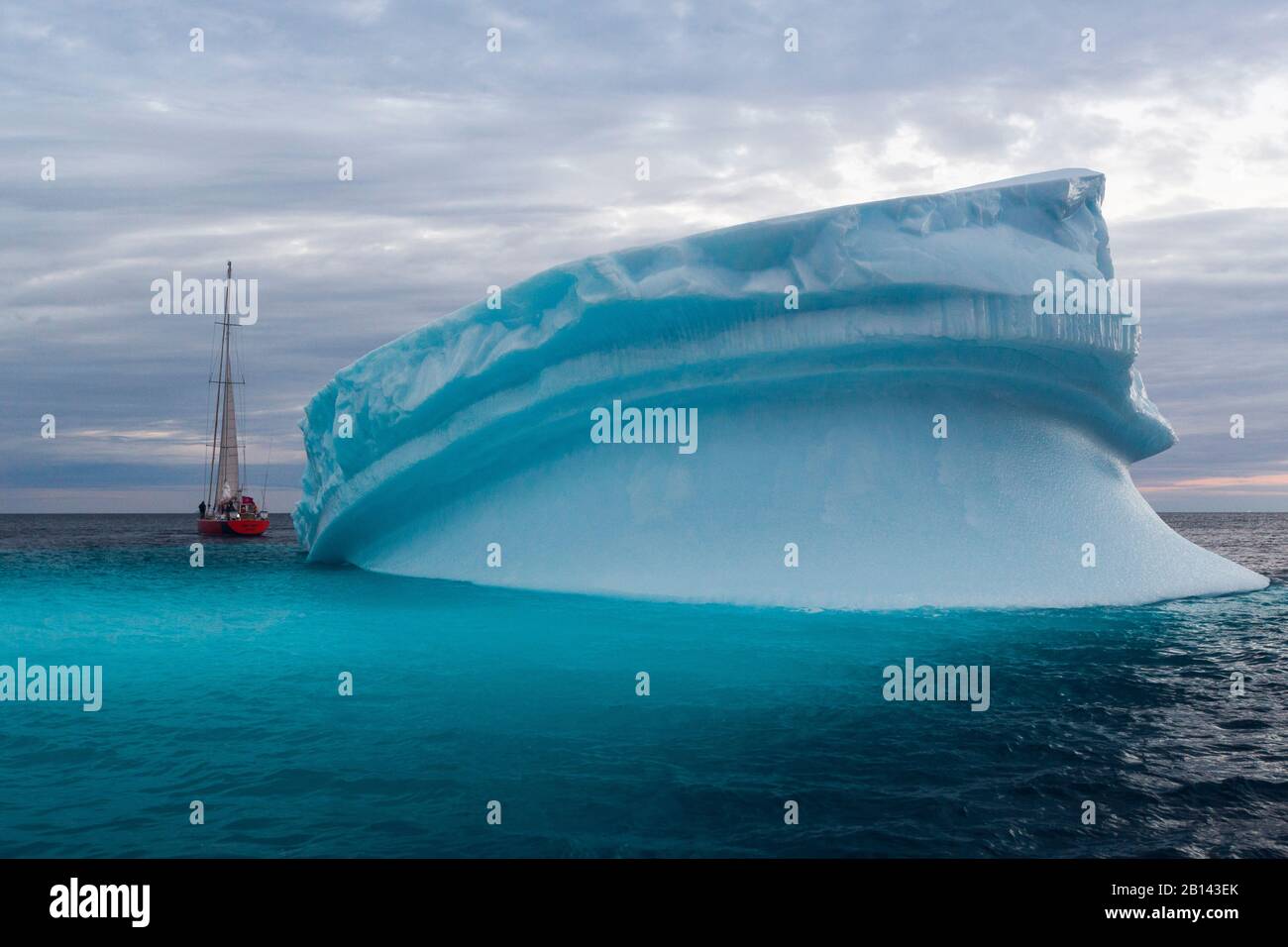 Icebergs and sailboat in Disko Bay on Midsummer, Greenland Stock Photo