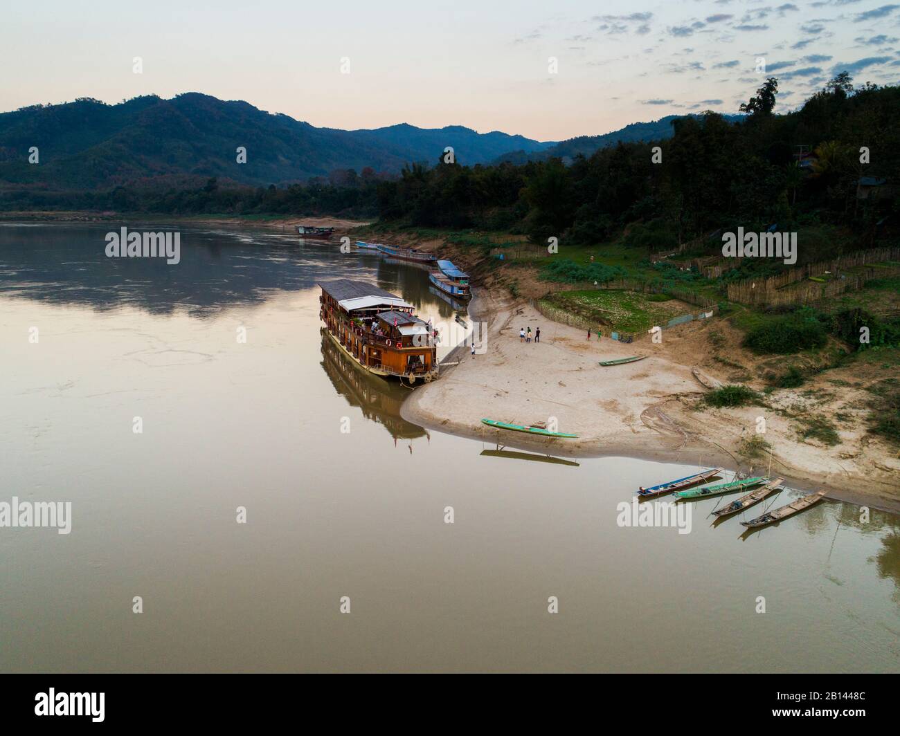 River cruise ship Mekong Sun lies at night on a shore, Laos Stock Photo