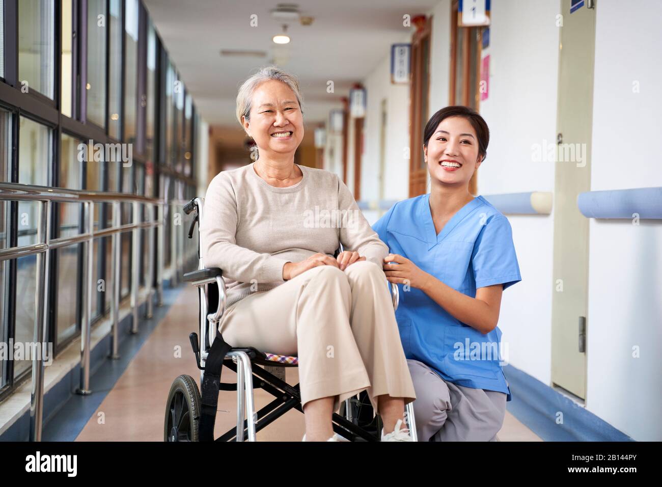 asian senior woman and her caregiver looking at camera smiling Stock Photo