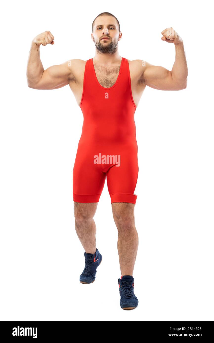 Strong strong young man in a sports red tights stands showing biceps