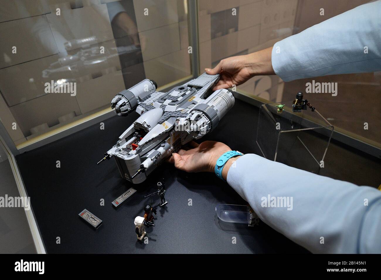 A Lego assistant holds a model of Star Wars The Mandalorian ship exclusive for Amazon while on display in a glass case at the annual New York Toy Fair 2020 at the