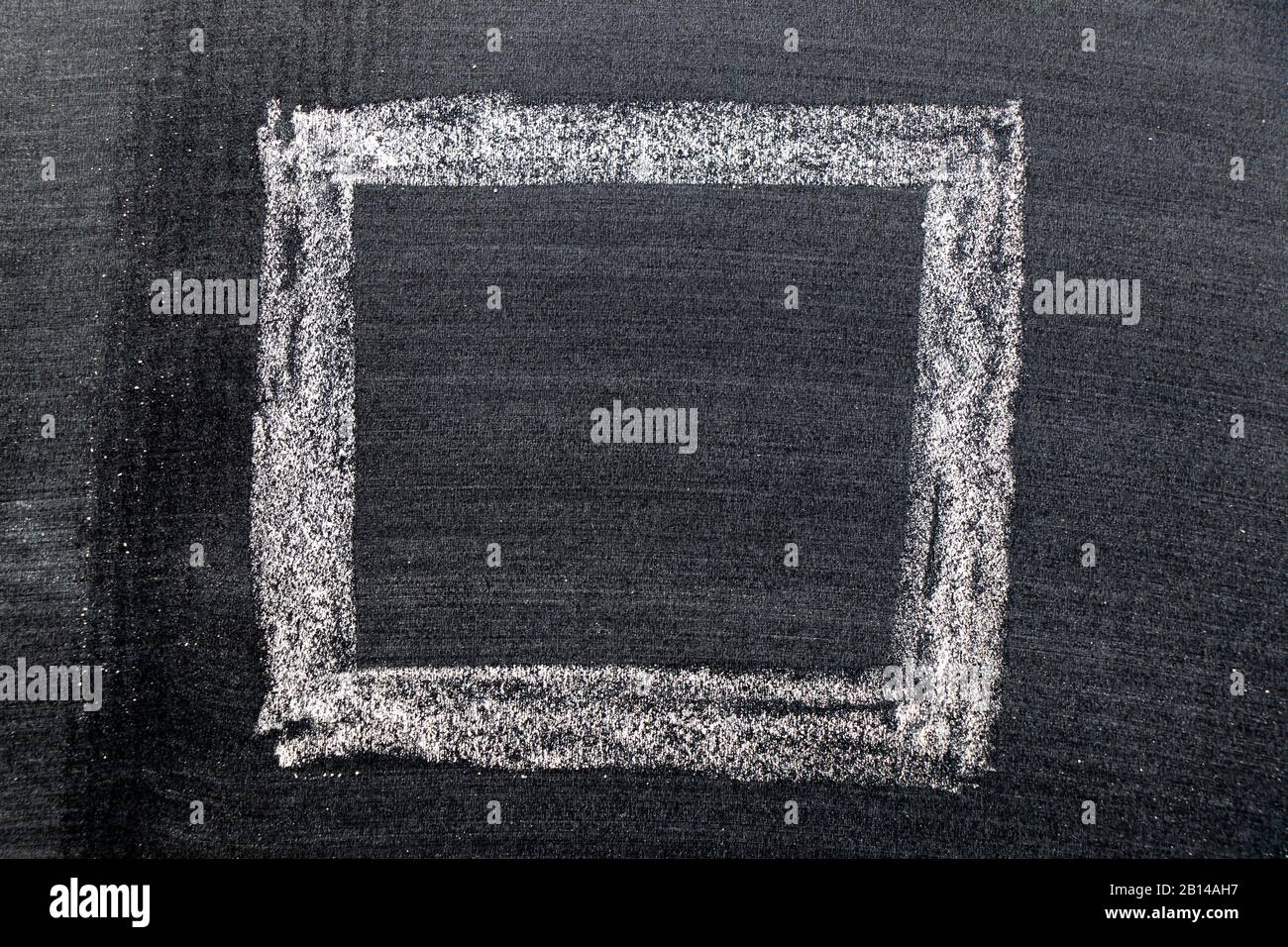 White color chalk hand drawing in square shape on black board