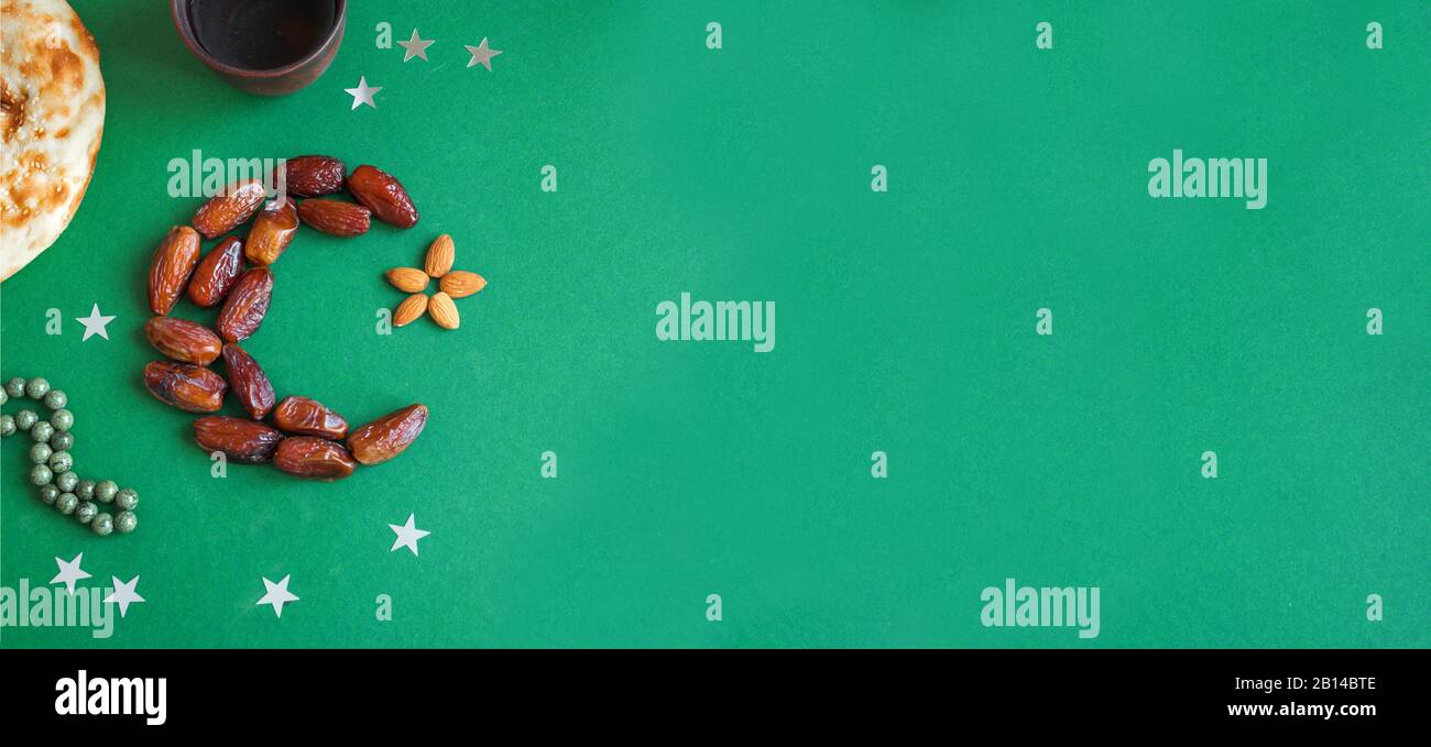 Ramadan kareem with dates arranged in shape of crescent moon, water and ...