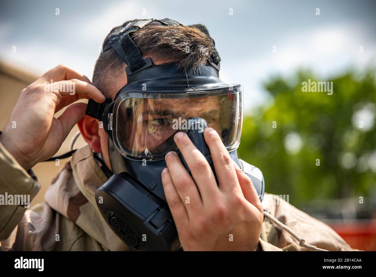 A U.S. Marine with Marine Aircraft Group 41, 4th Marine Aircraft Wing, puts on a M-50 joint service general purpose mask during a chemical, biological, radiological and nuclear (CBRN) individual survival skills course in support of Sentinel Edge 19 (SE19) at Canadian Forces Base Cold Lake, Canada, June 14, 2019. CBRN training test Marines abilities to respond in the event of chemical, biological, radiological or nuclear contamination. Training exercises such as SE19 ensure Reserve Marines are proficient and capable of successful integration with active-duty Marines, making Marine Forces Reserv Stock Photo