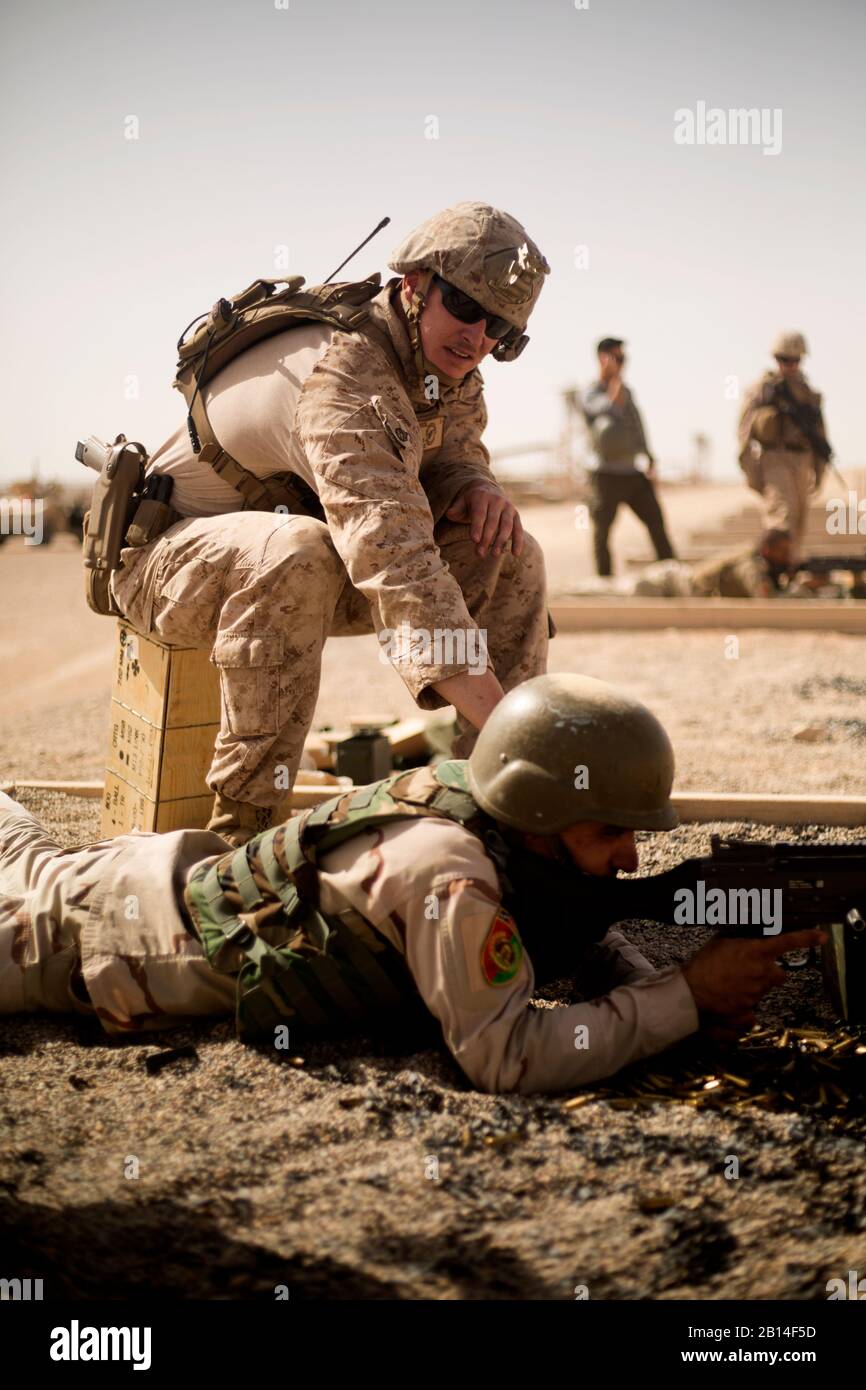 A U.S. Marine Corps adviser assigned to Task Force-Southwest coaches a soldier with the Afghan National Army during a M240B machine gun range at Camp Shorabak, in Helmand province, Afghanistan, Sept. 5, 2018. The range allowed soldiers to hone their lethal and accurate machine gun firing skills and assist them in maintaining and expanding the security belt in central Helmand to facilitate safe and secure provincial elections this October. (U.S. Marine Corps photo by Sgt. Sean J. Berry) Stock Photo