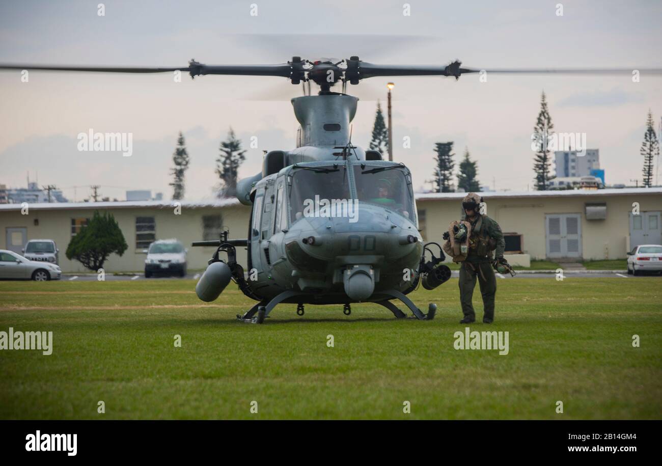 U.S. Marine Corps crew chief unloads flight gear from a UH-1Y Venom at Camp Foster, Okinawa, Japan, Dec. 15, 2017. Marine Light Attack Helicopter Squadron 369 provided Lt. Gen. Brian D. Beaudreault, deputy commandant of plans, policies and operations, a flight around the Okinawa Prefecture to assess the service quality of the Marine Corps chowhalls. The “gunfighters’” readiness to act upon a moment’s notice is crucial to maintaining a stronger, more capable forward deployed force in the Indo-Asia-Pacific region. HMLA-369, Marine Aircraft Group 39, 3rd Marine Aircraft Wing, is currently forward Stock Photo