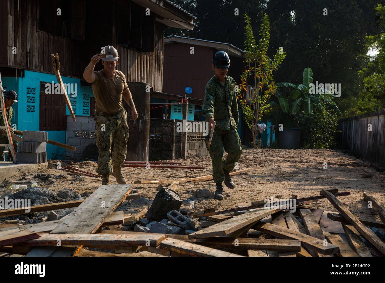 U.S. Navy Builder 2nd Class Joshua Spires, Naval Mobile Construction Battalion 4 crew leader, from Gresham Ore., left, and Singapore Army 2nd Sgt. Johnathan Loo, Army Combat Engineer Group compile left-over building material, Feb. 7, 2018, during exercise Cobra Gold 2018. Soldiers and sailors from the Royal Thai Navy, Singapore Army and U.S. Navy, worked together to build a multi-purpose class room for the Wat Sombum Naram school in Rayong province, Thailand. Humanitarian civic action programs will improve the quality of life as well as the general health and welfare of civilian residents in t Stock Photo