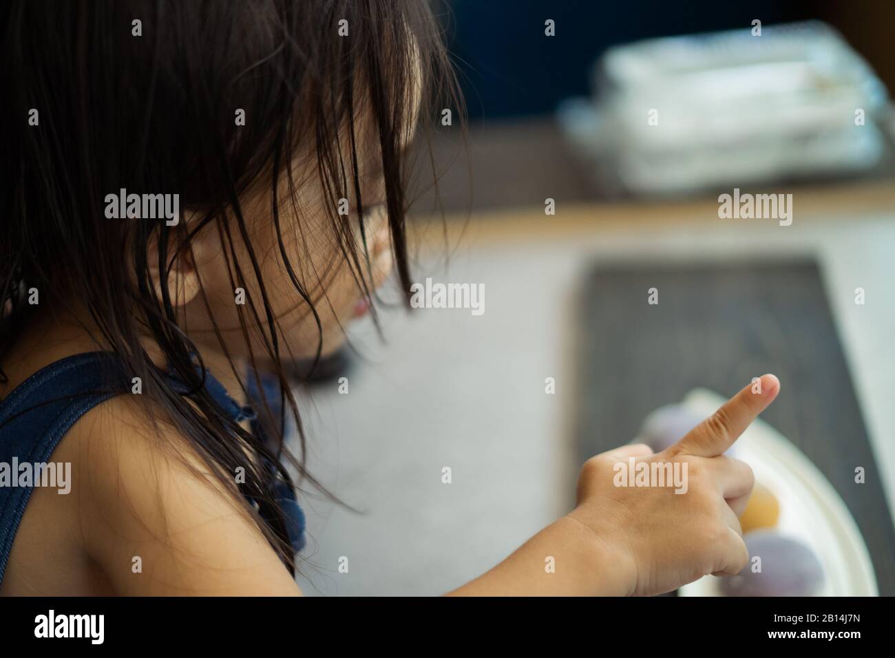 Asian toddler girl pointing somewhere. Rear view. Stock Photo