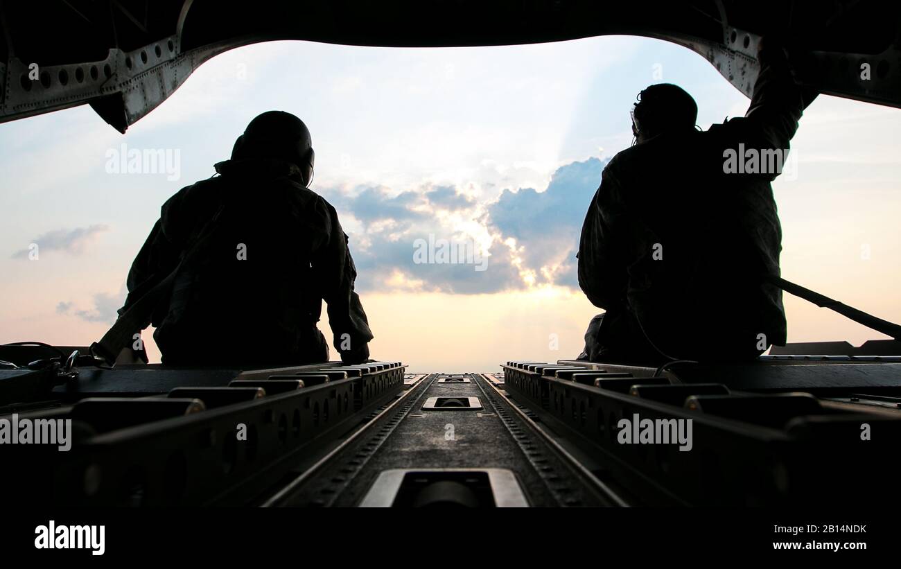 U.S. Army Sgt. 1st Class Roy Chandler, left, and Spc. Benjamin Grogan, assigned to Bravo Company, 1st Battalion, 169th Aviation Regiment, Alabama Army National Guard, sit on the tail of a CH-47 Chinook helicopter in route to deliver hay bales to cattle that have been stranded by Hurricane Harvey near Hampshire, Texas, Sep. 3, 2017. The Department of Defense is conducting Defense Support of Civil Authorities operations in response to the effects of Hurricane Harvey. DSCA operations are part of the DoD’s response capability to assist civilian responders in saving lives, relieving human suffering Stock Photo