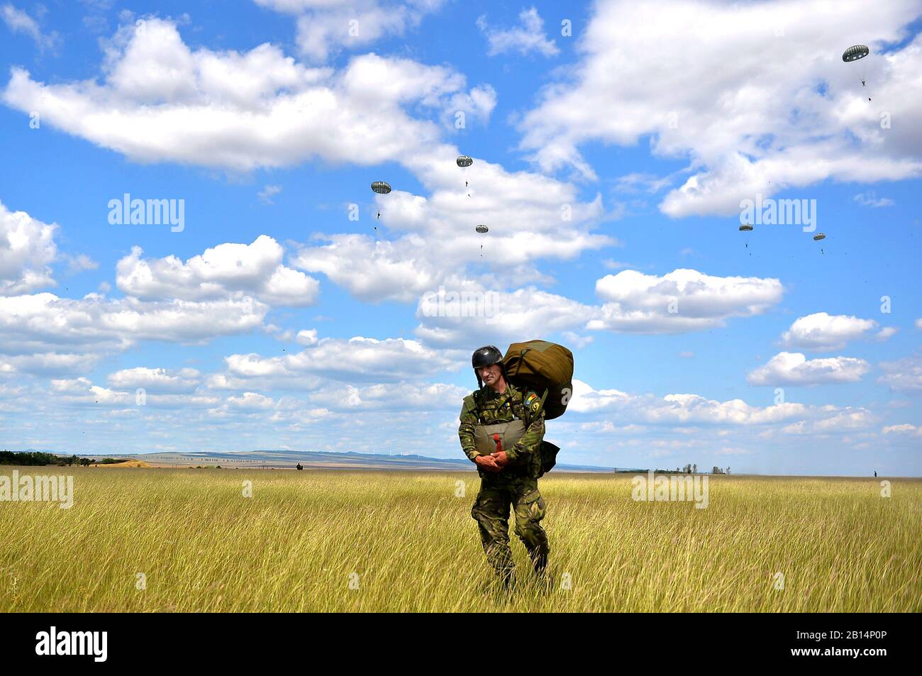 A Romanian paratrooper hikes back to his pick-up point after jumping from a U.S. Air Force C-130J during a bilateral exercise at Boboc Air Base, Romania, Aug. 24, 2017. Carpathian Fall 2017 showcased the partnership between U.S. and Romanian forces, and involved airdrops of cargo and personnel, tactical evasive maneuvers, and assault landings. (U.S. Air Force photo by Airman 1st Class Joshua Magbanua) Stock Photo