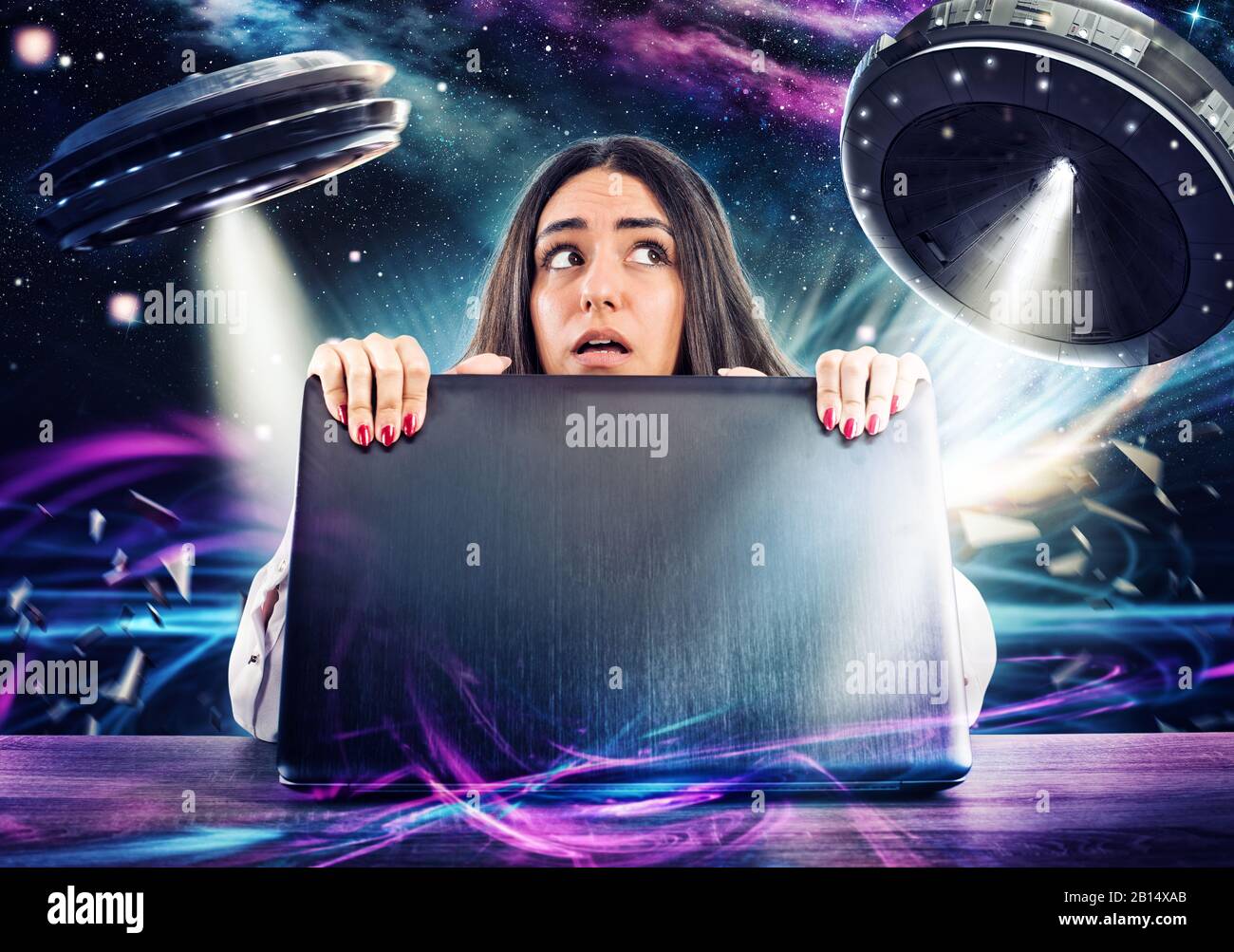 Girl works on the computer surrounded by UFOs. Concept of internet espionage and security Stock Photo