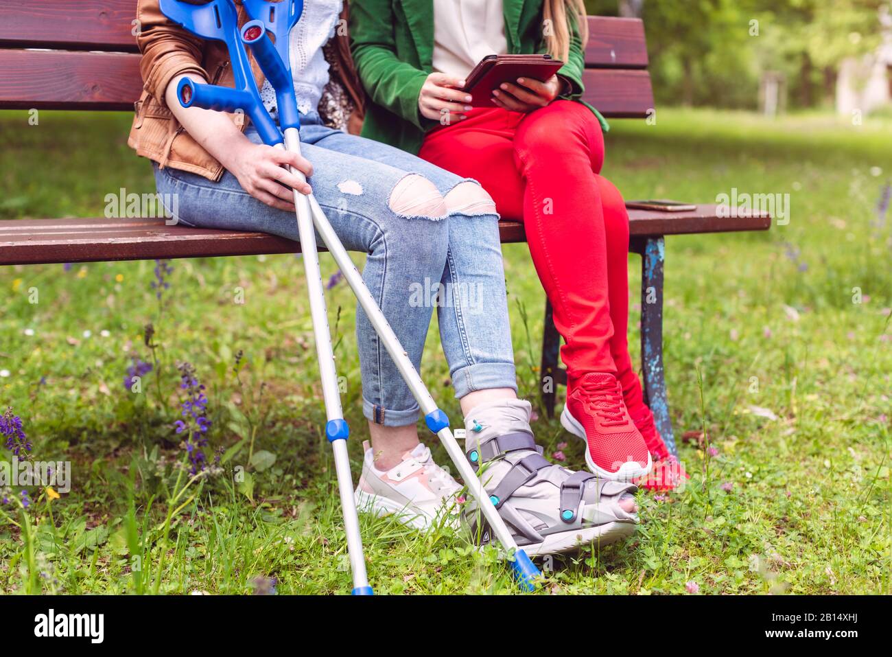 Woman spending time with her friend having a broken leg Stock Photo