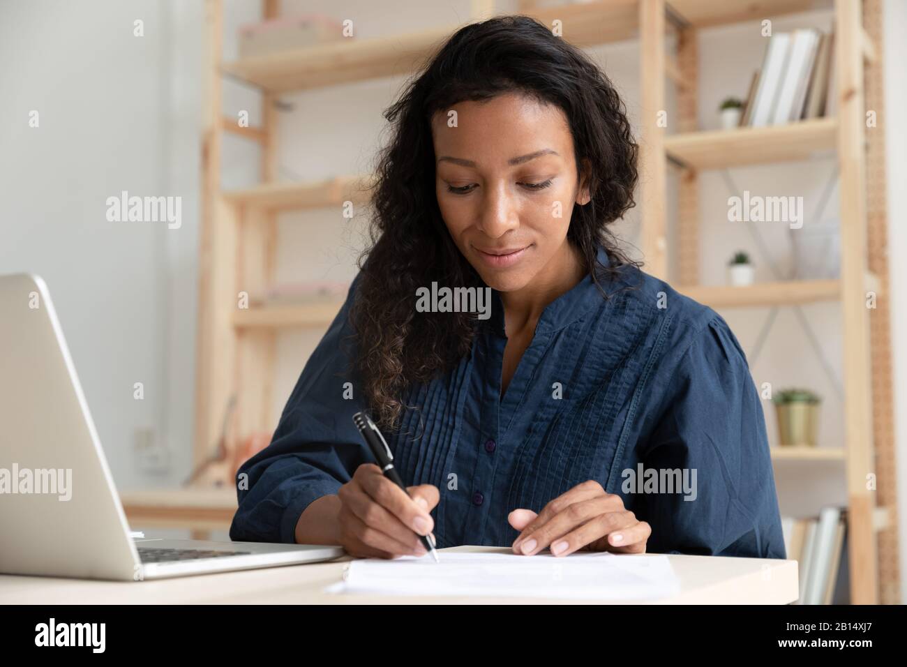 Concentrated professional writing notes while watching webinar. Stock Photo