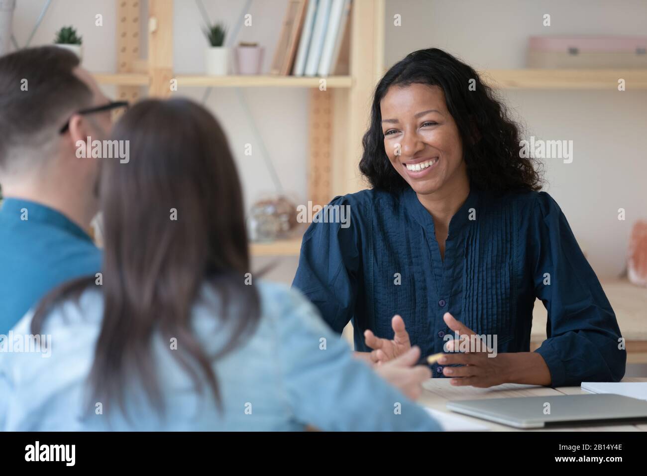 Smiling professional african american financial advisor talking to clients. Stock Photo