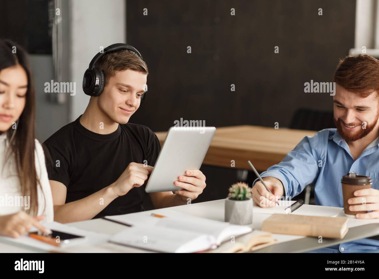 Student guy surfing net on tablet in library Stock Photo