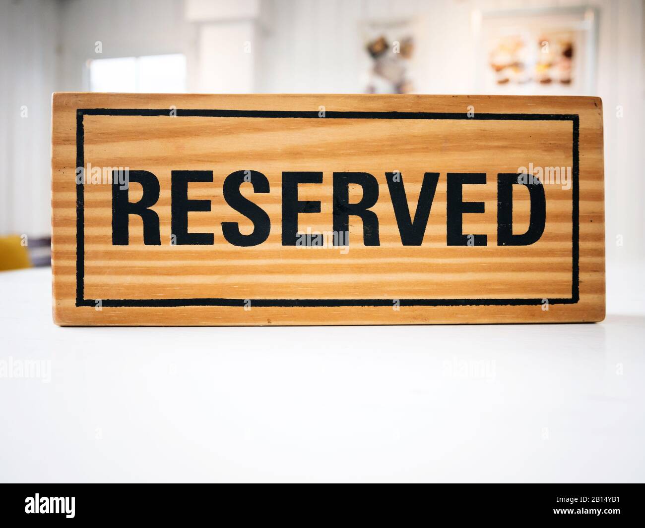 Reservation seat at restaurant for dating on celebrate day concept. Restaurant with reserved wooden sign on white table with cafe decorate places sett Stock Photo