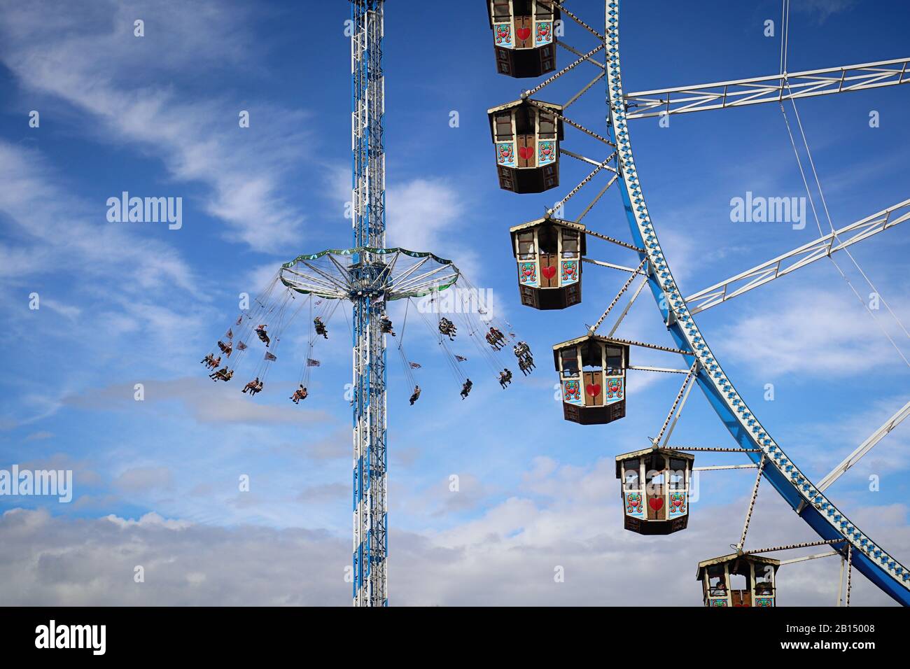 MUNICH, GERMANY - OCTOBER 1, 2019 Giant ferris wheel with Bavarian style booths and free fall ride at the Oktoberfest in Munich Stock Photo