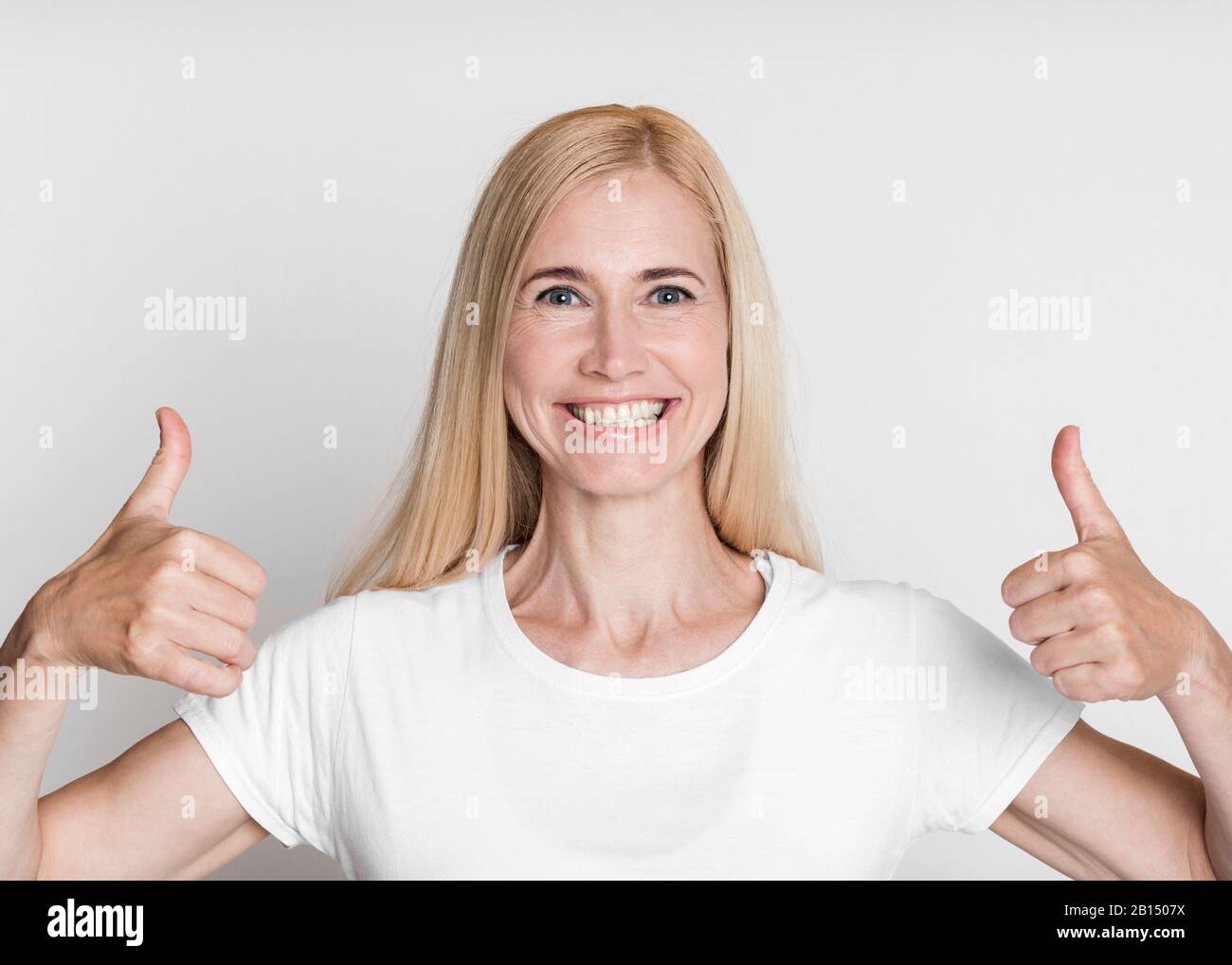 Closeup of mature woman showing thumb up and smiling Stock Photo