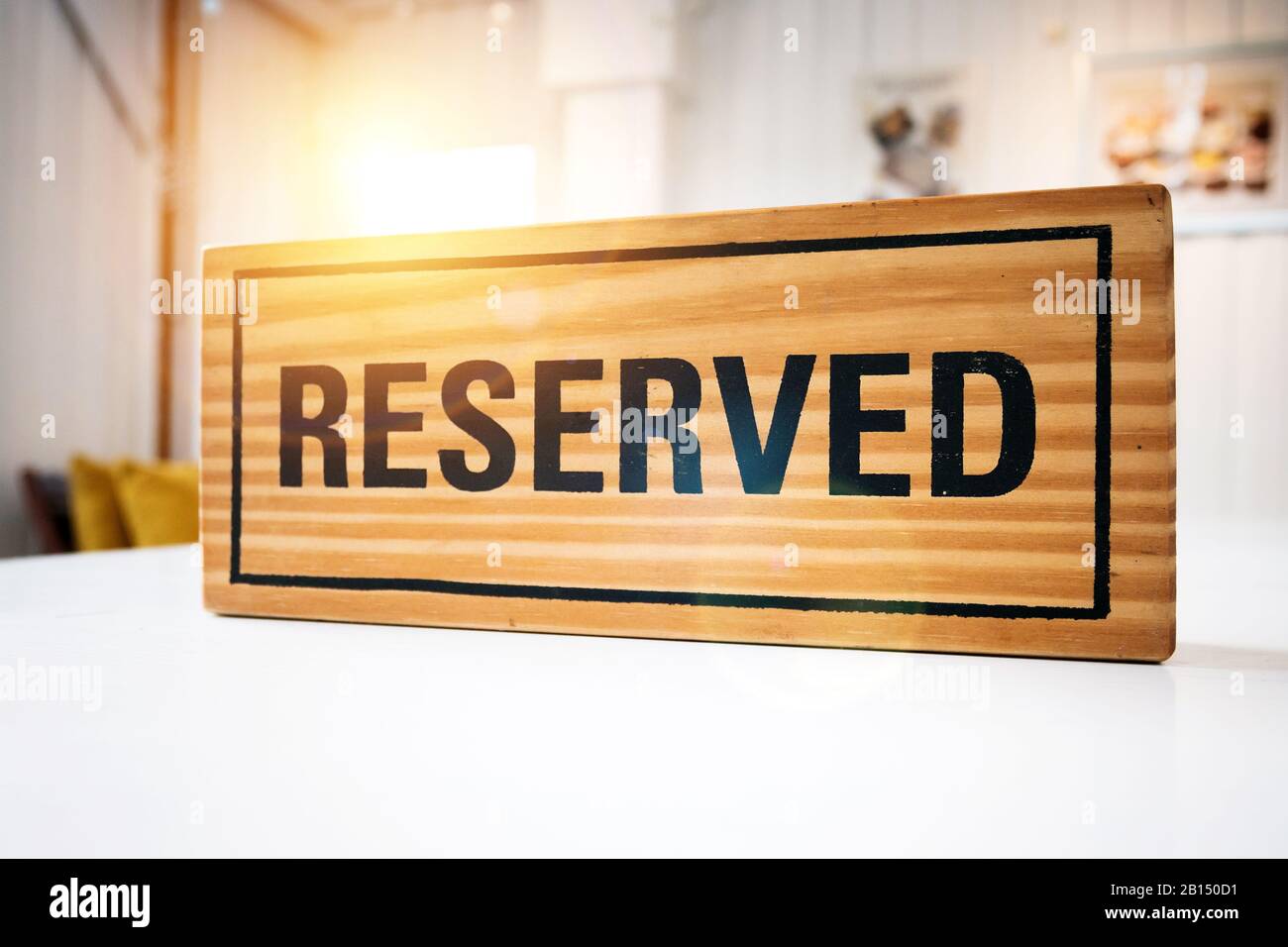 Reservation seat at restaurant for dating on celebrate day concept. Restaurant with reserved wooden sign on white table with cafe decorate places Stock Photo