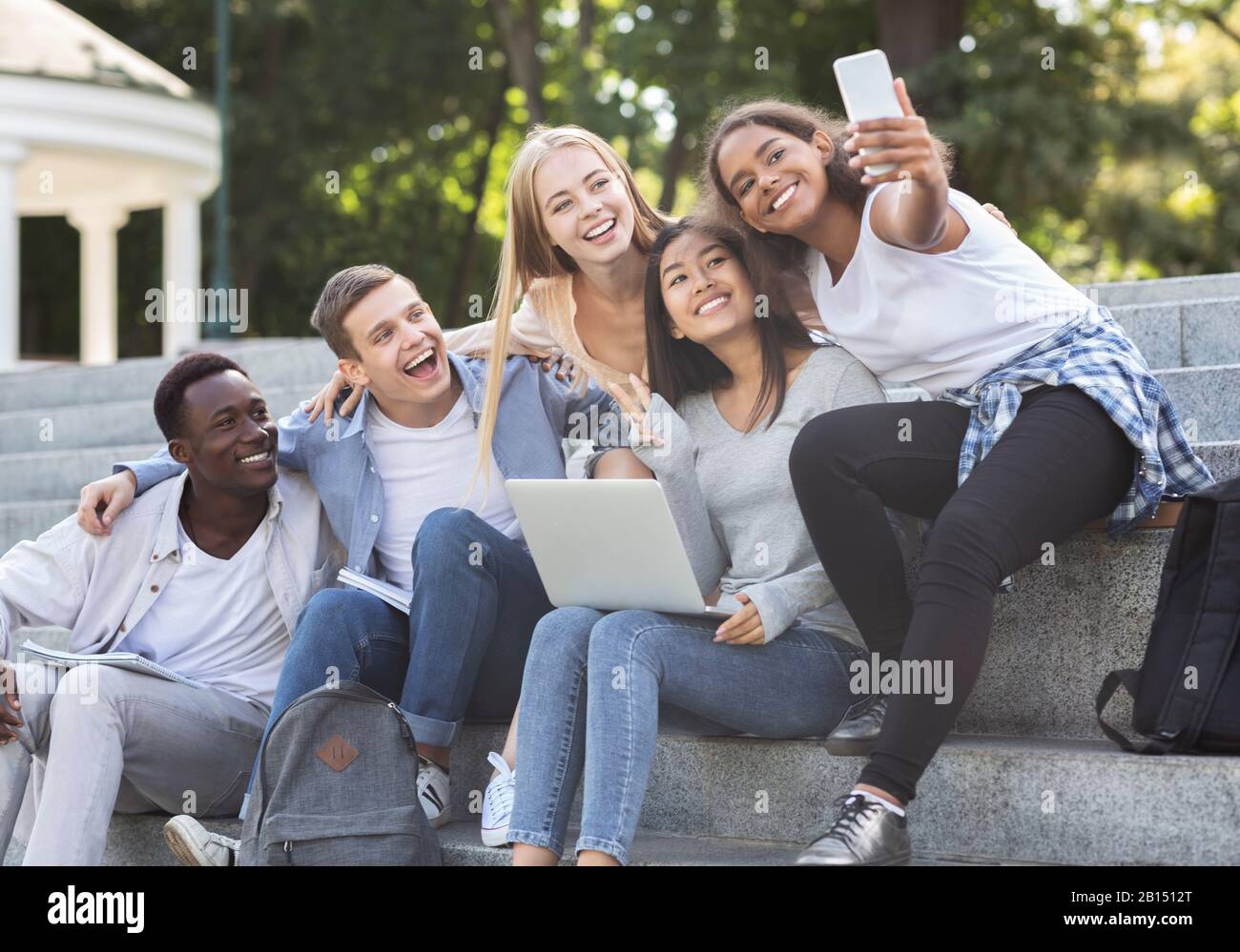Happy multiethnic students taking selfie while studying in city Stock ...
