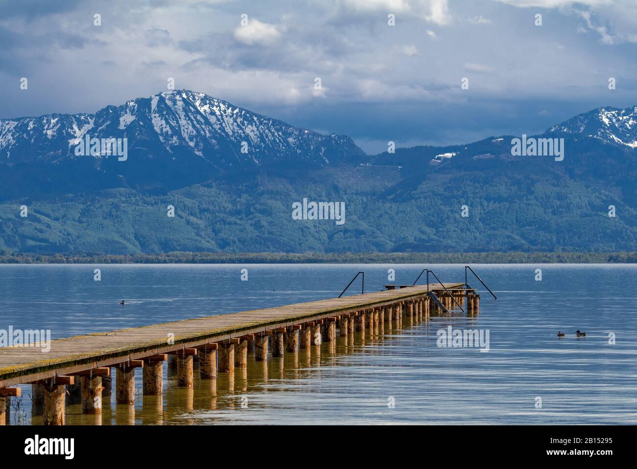 lake Chiemsee with bathing jetty and snow covered Alps in spring , Germany, Bavaria, Lake Chiemsee Stock Photo