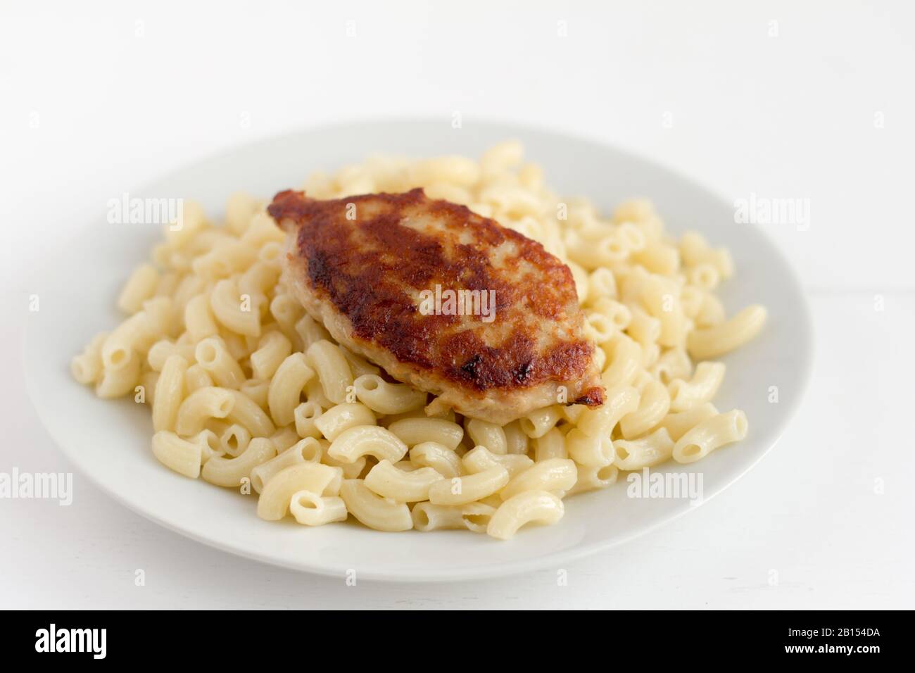 Pasta with a chop.Regular home-cooked food.Boiled horns and fried cutlet Stock Photo